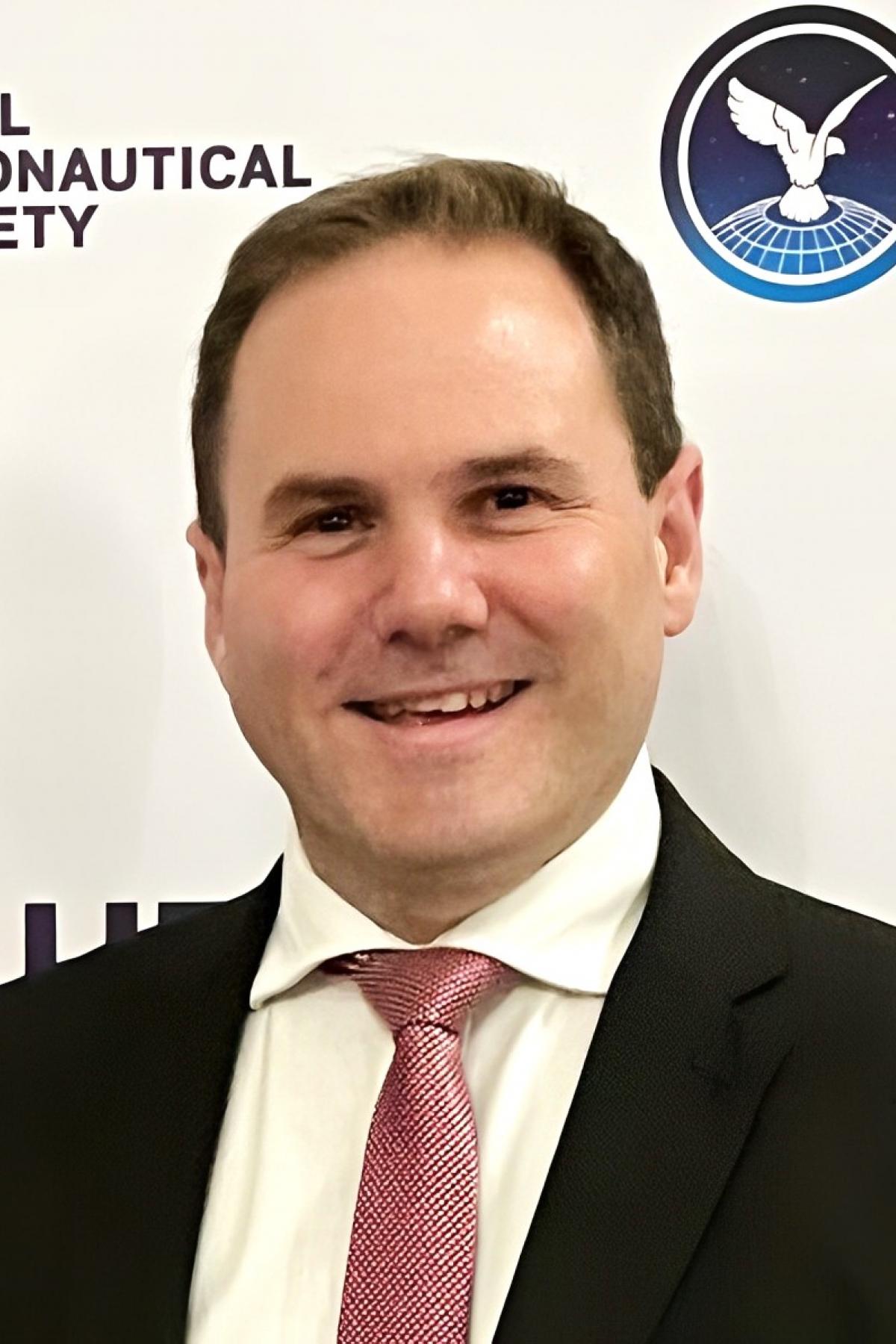 A portrait of Tom Smith in a suit, smiling