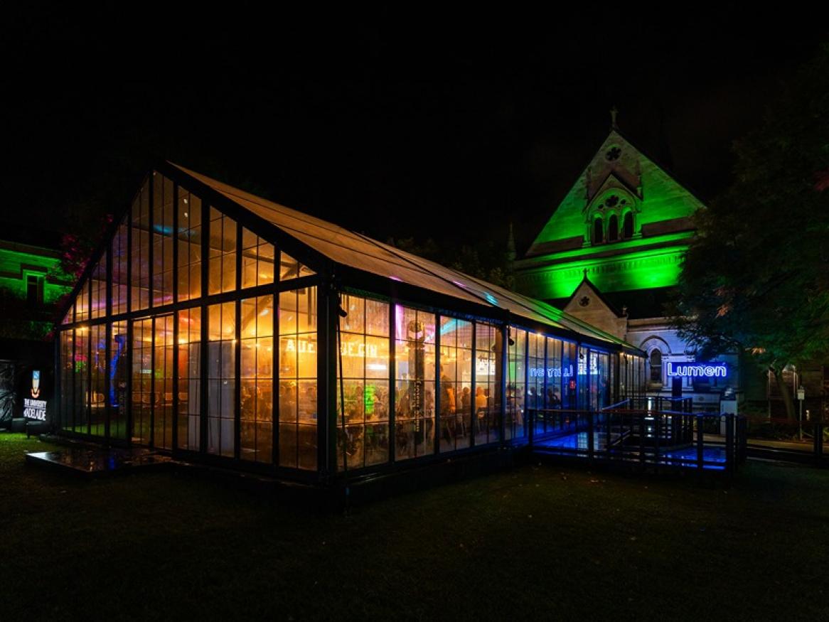 The outside of the Lumen Bar marquee at night, in front of Elder Hall