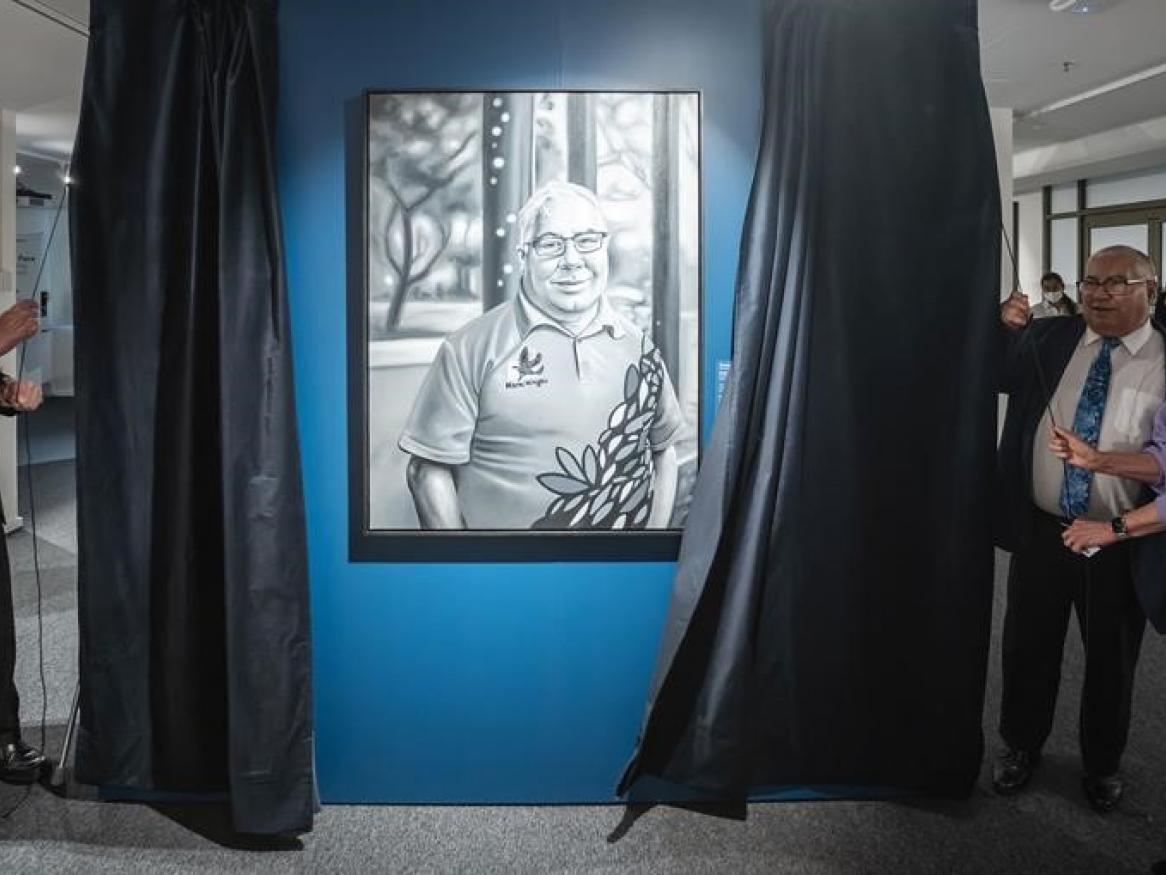 Image shows the unveiling of Uncle Rodney O'Brien's portrait by Uncle Lewis O'Brien, Chancellor Catherine Branson, and Uncle Rodney