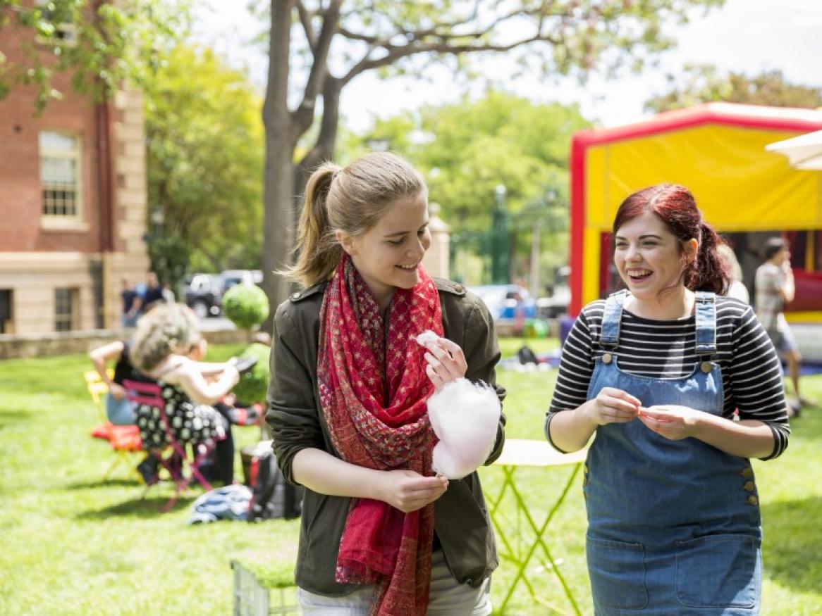 Students on the lawns walking with fairy floss, at an outside event
