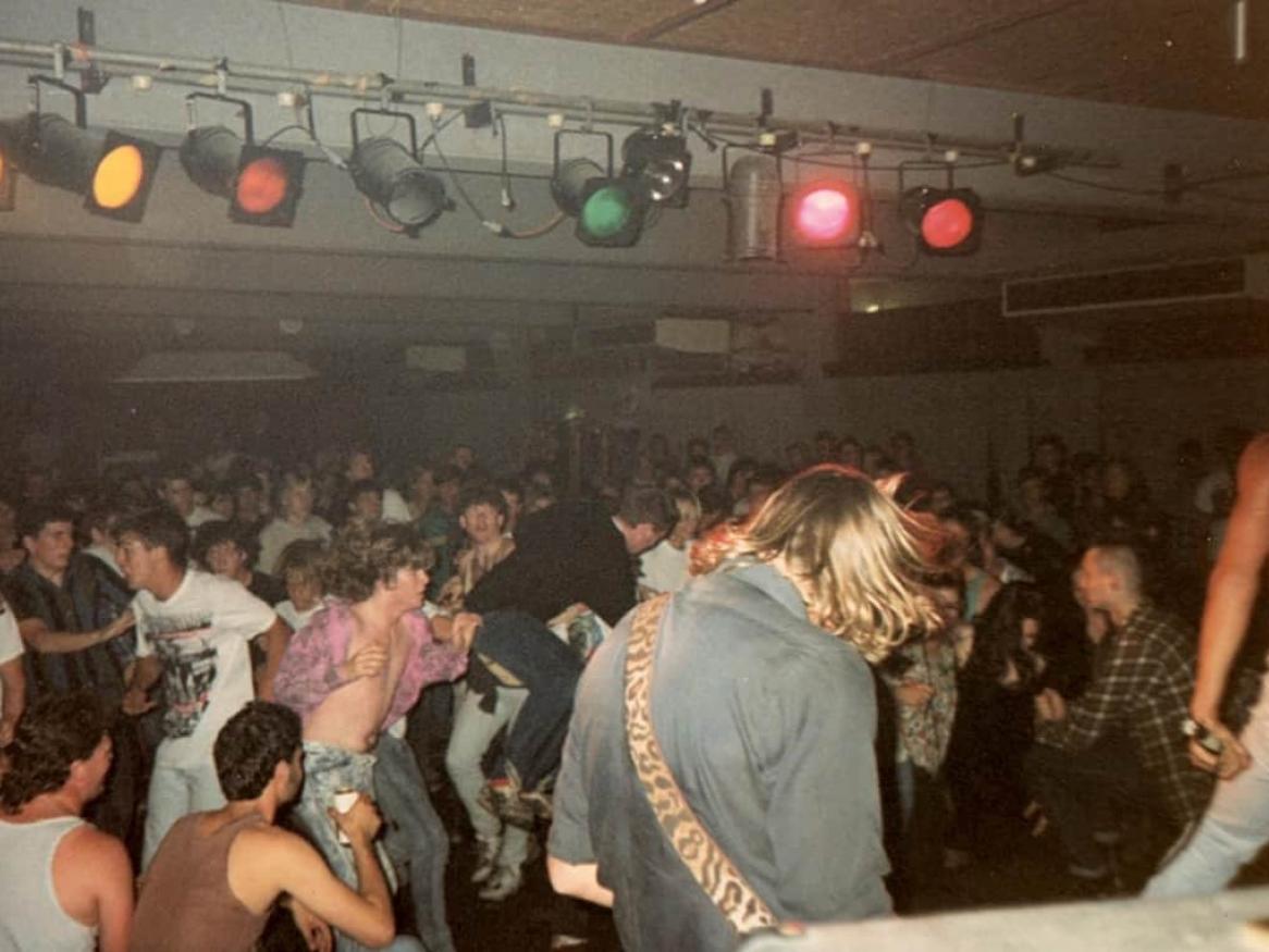 A gig in the UniBar in 1990: the audience dances before a stage,
