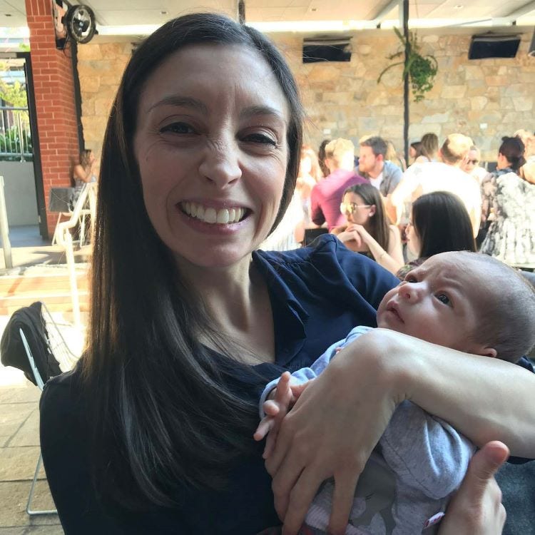 Photo of Ella holding baby.