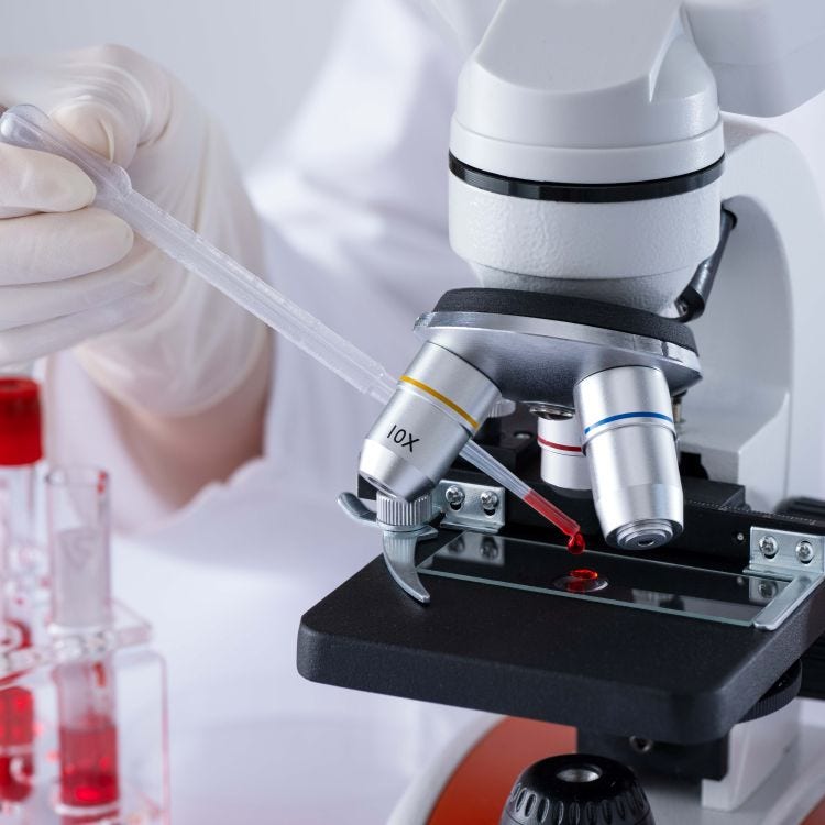 Stock image of a scientist pipetting blood onto a microscope slide