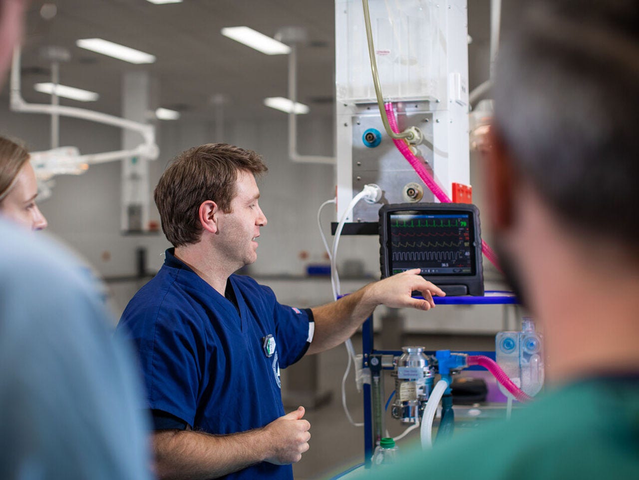 A lecturer taking a class in a hospital setting