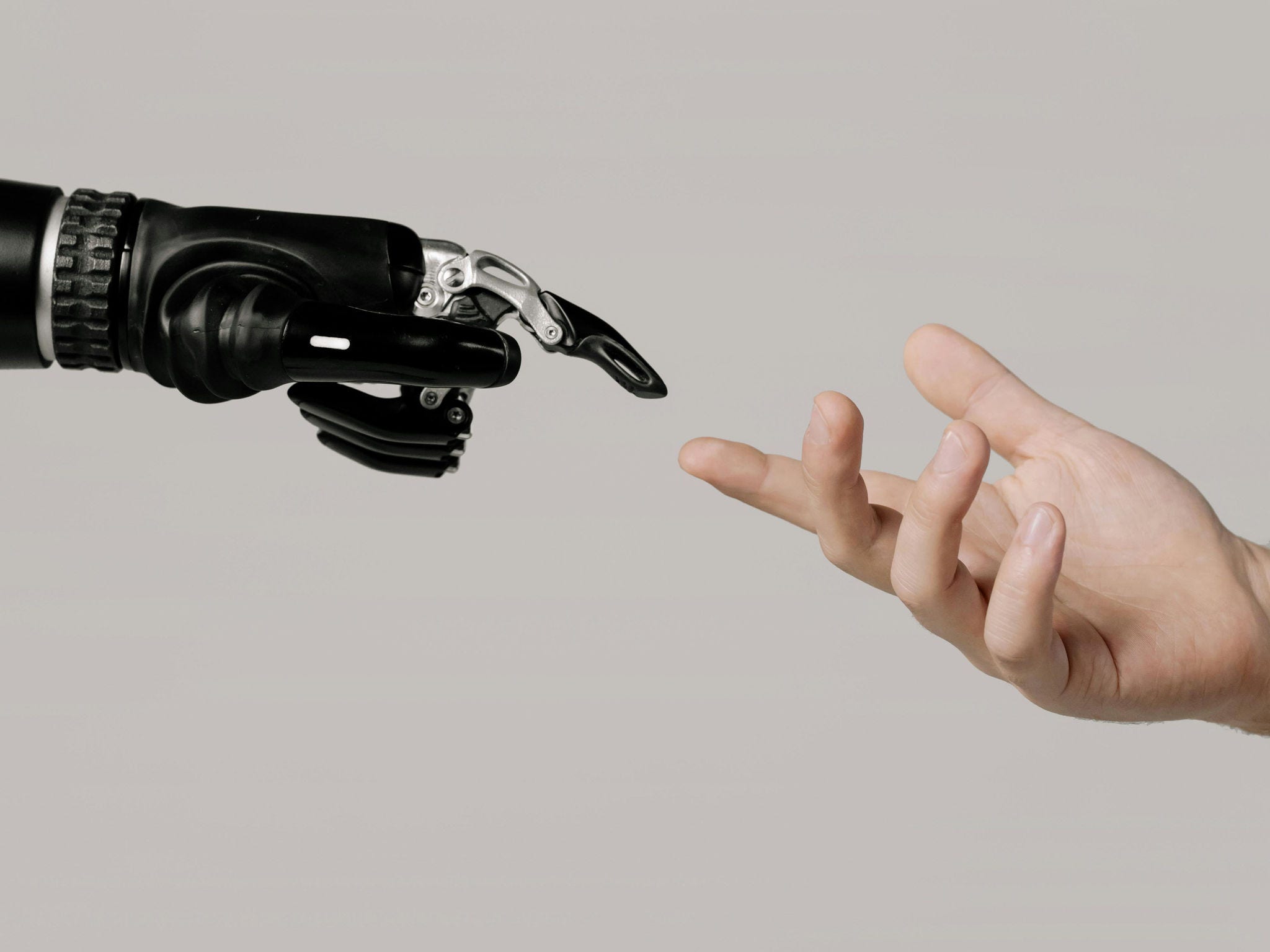 A human and reaching for a mechanical hand