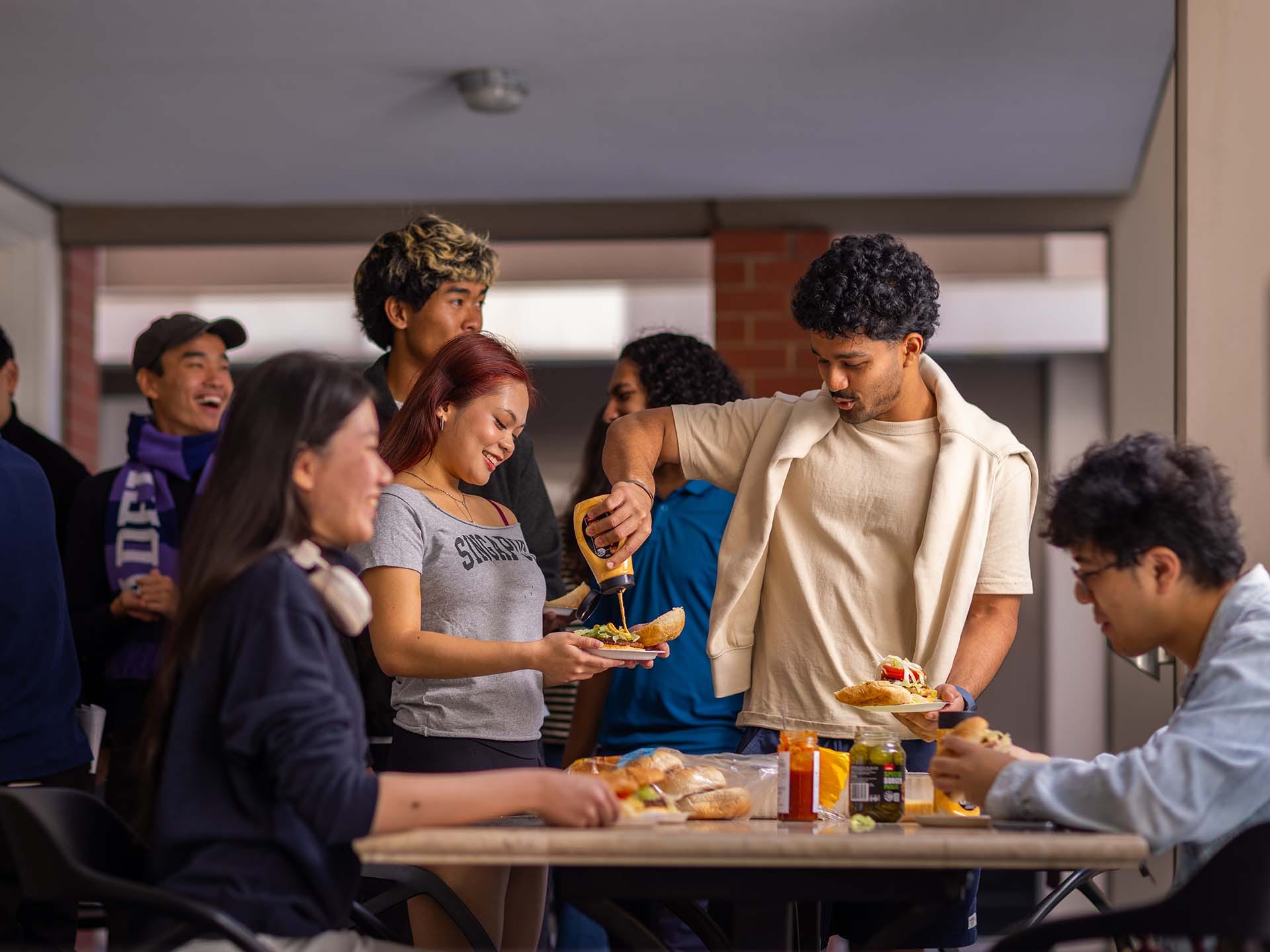 Residents using the common kitchen space at Adelaide University Village student accommodation