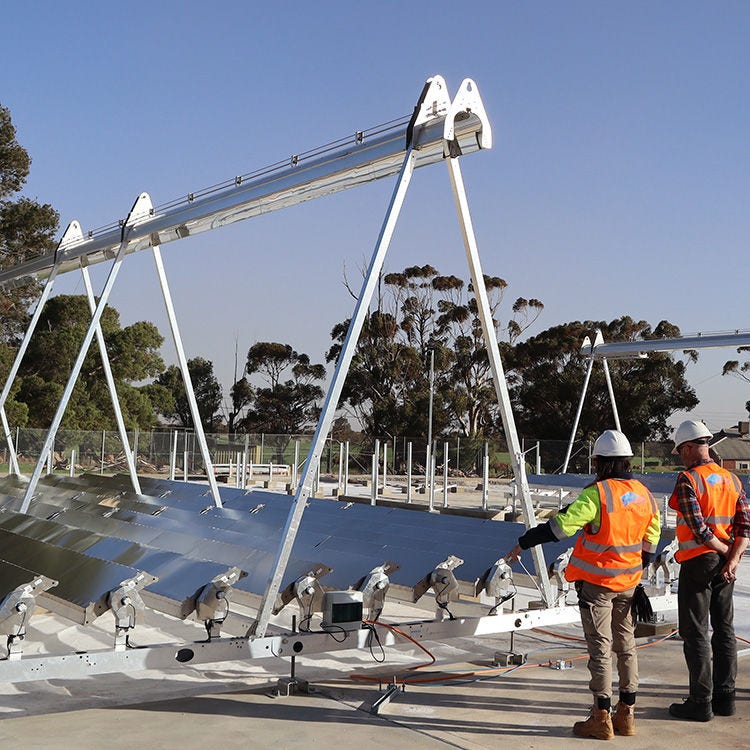 two people in hi-vis looking at equipment