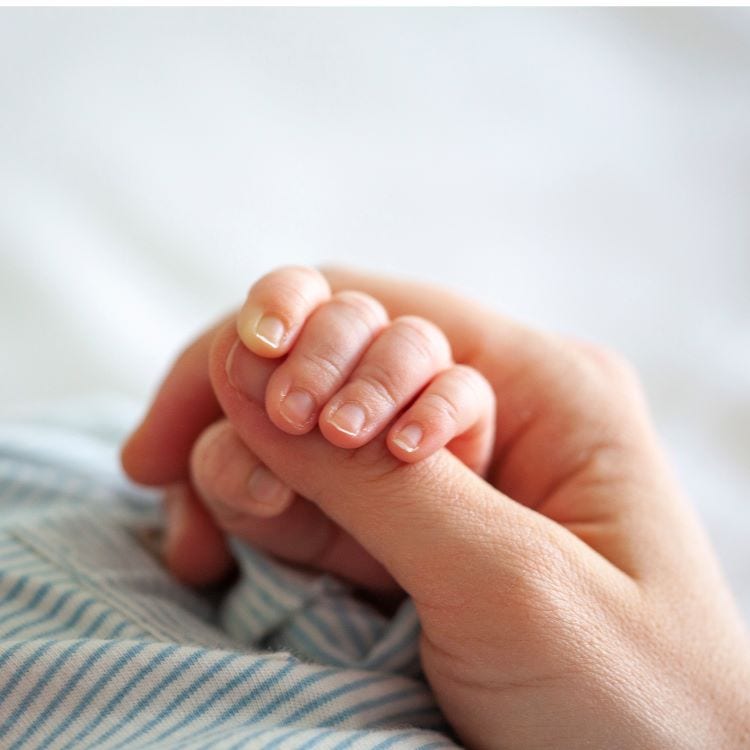 Mother holding baby's hand