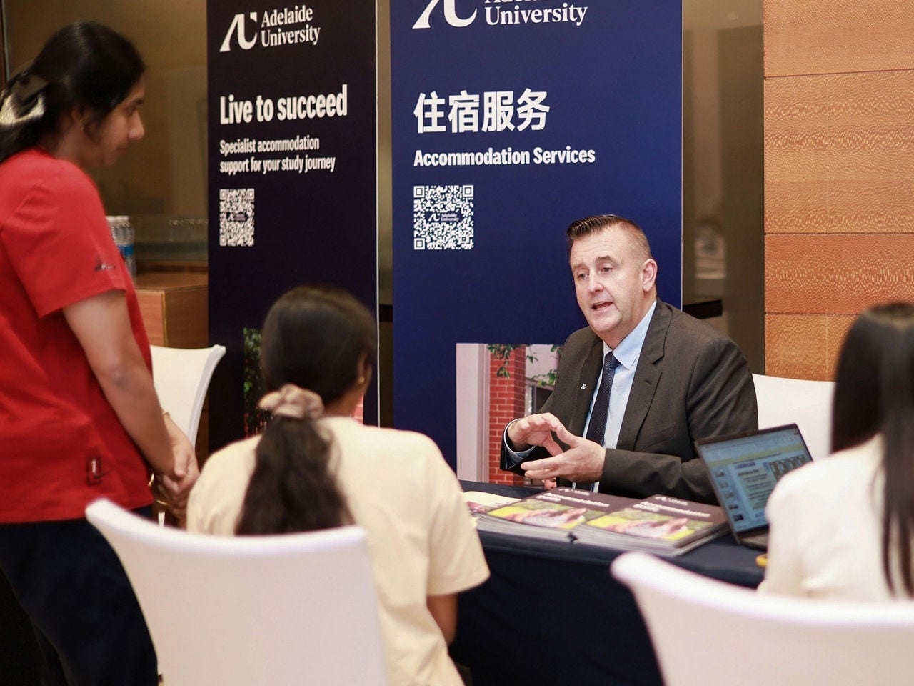 Support staff discussing accommodation options with prospective students