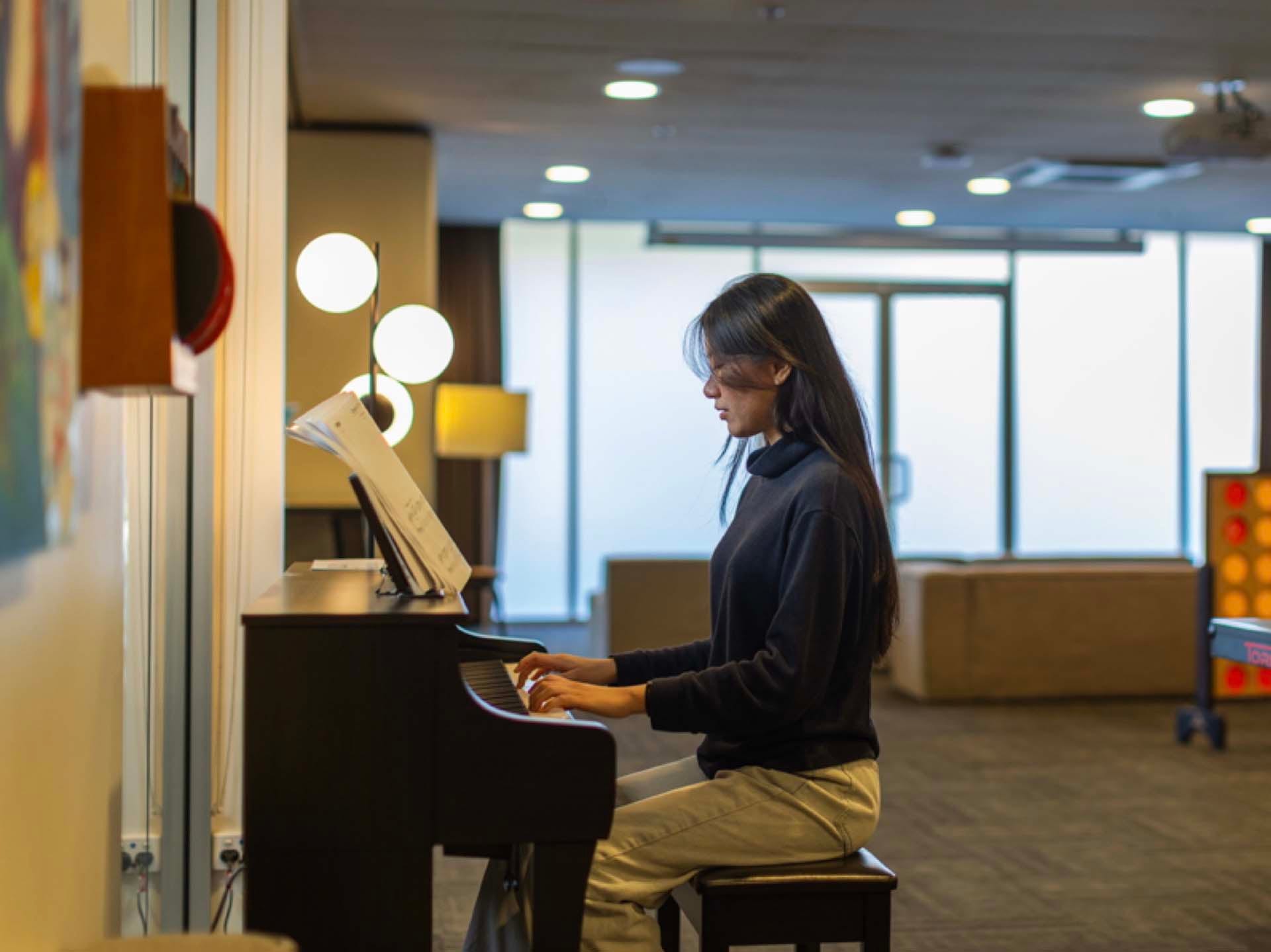Resident using the shared spaces at Adelaide University Village student accommodation