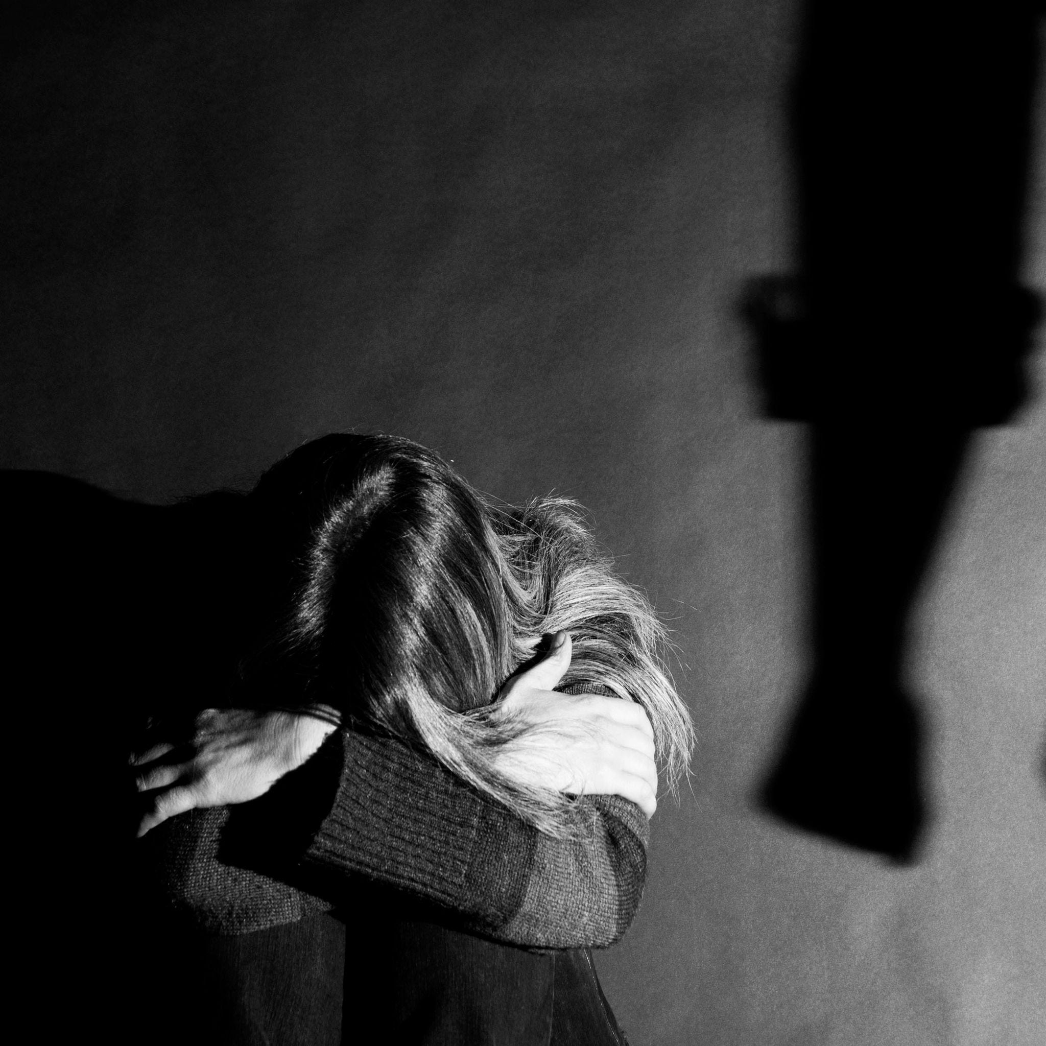 a shadowy image of a scared women facing away from camera