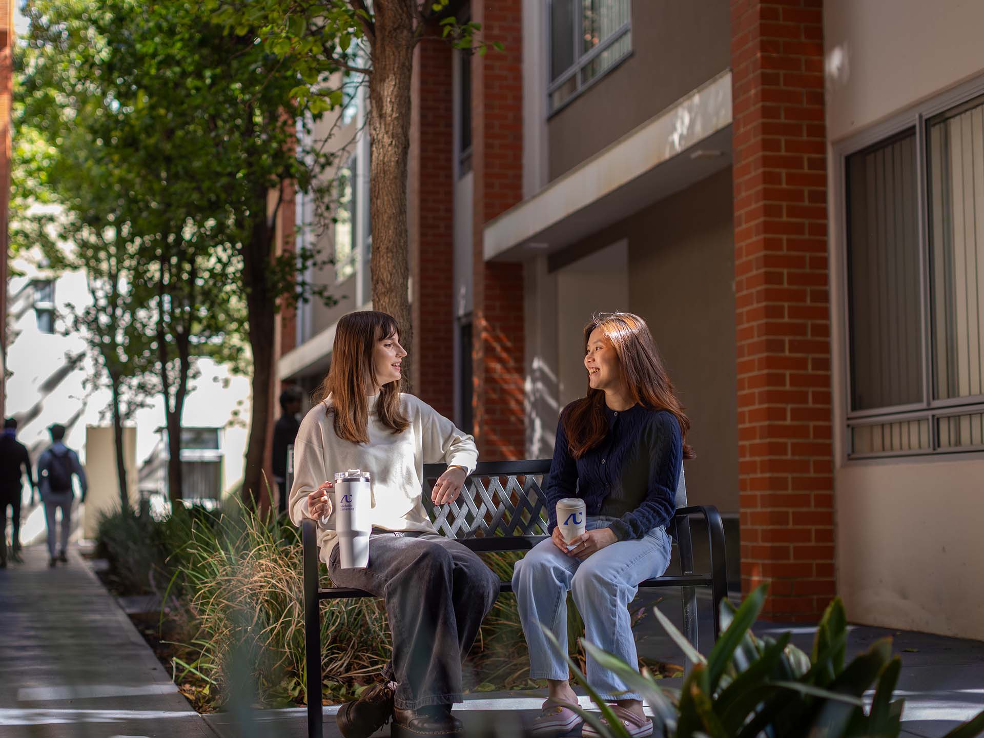 Residents using the common outdoor space at Adelaide University Village student accommodation