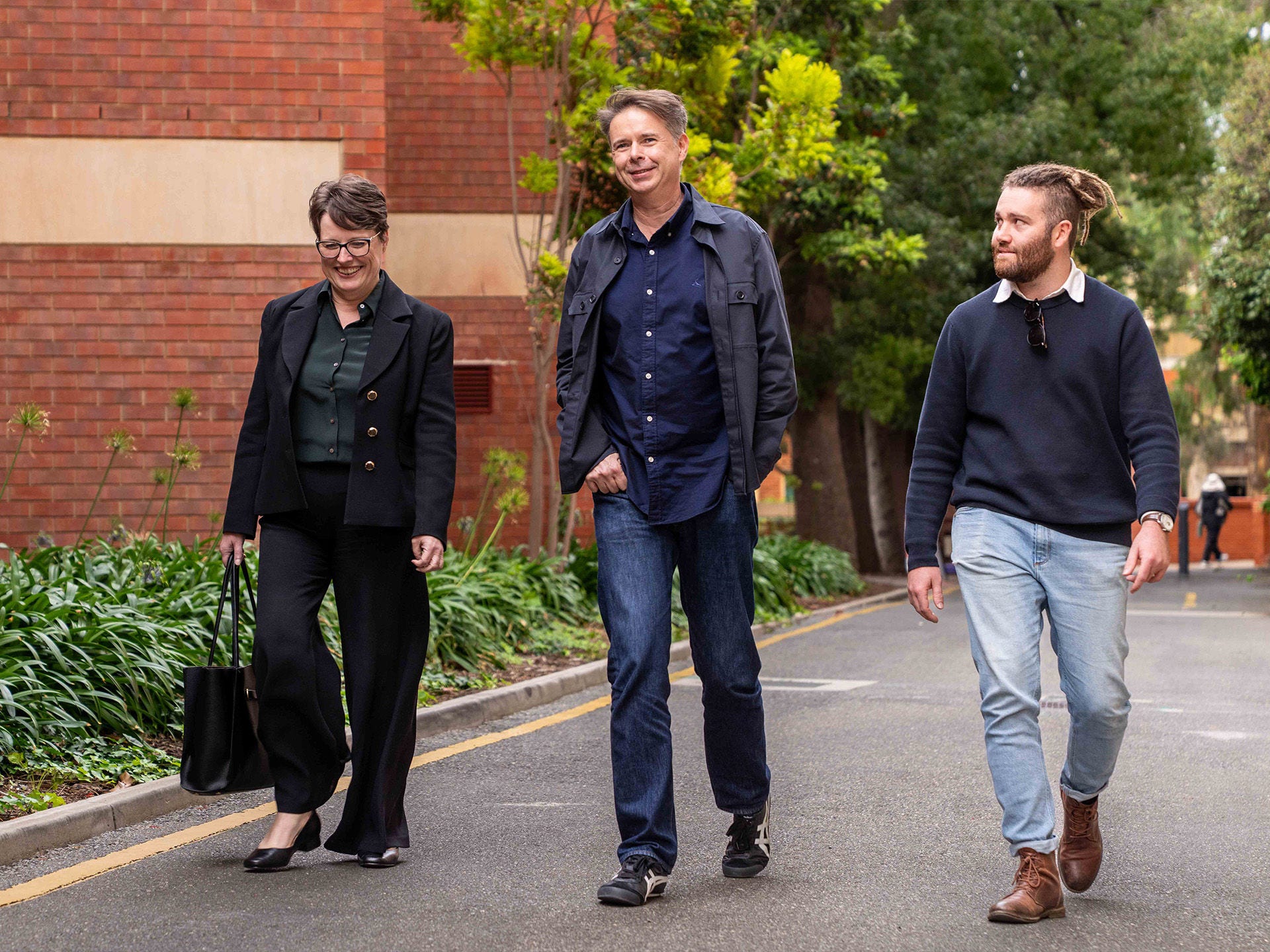 Episode 1, AI: The Electricity of Our Future — How universities can power what’s next: Vice Chancellor and President Nicola Phillips, Professor Anton van den Hengel and postgraduate student Oliver Lack walking to studio. 