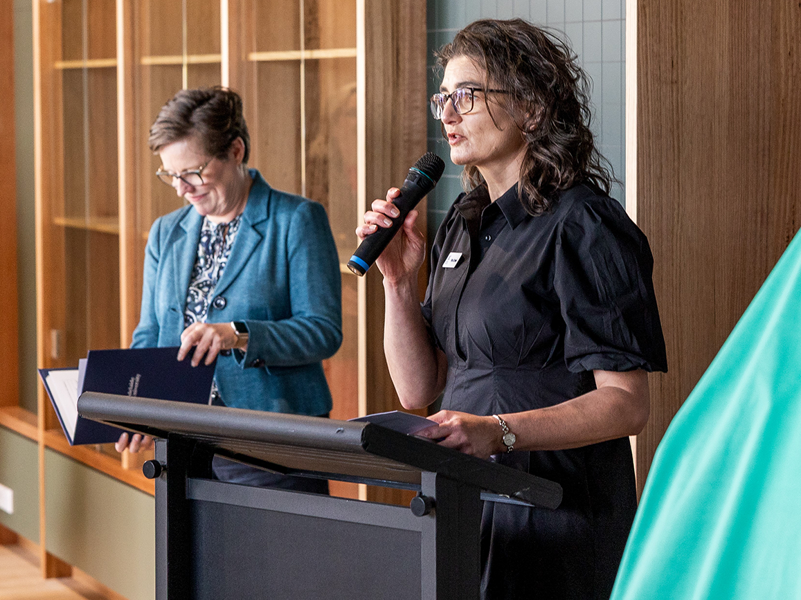 Peta Crewe giving a speech next to the Vice Chancellor