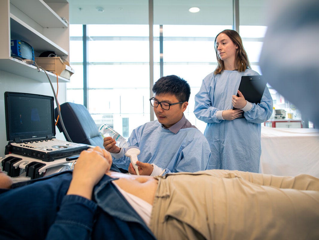An ultrasound practitioner preparing to scan a patient's abdomen