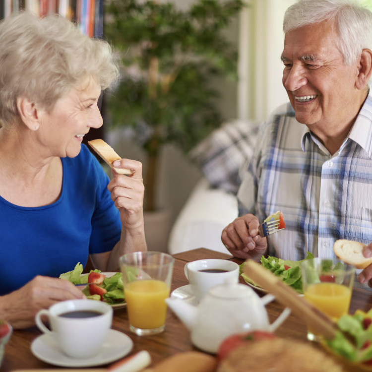 Stock image of an elderly man and woman eating at a table.