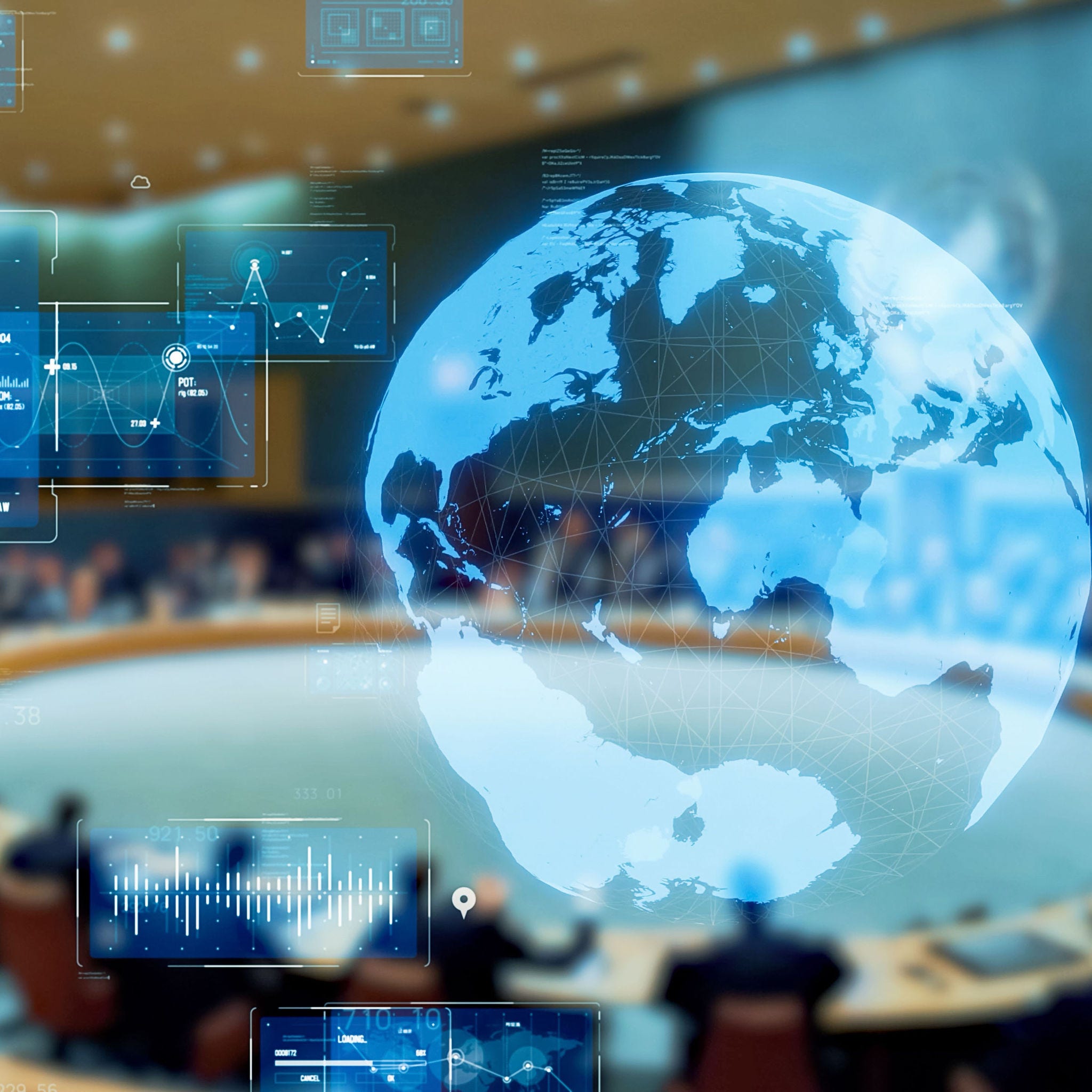 a circular table with seated delagates and a globe on screen