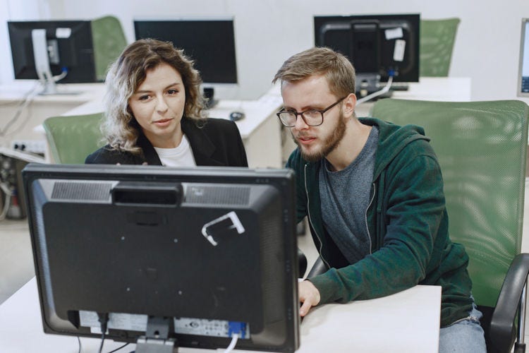 Two people looking at a computer