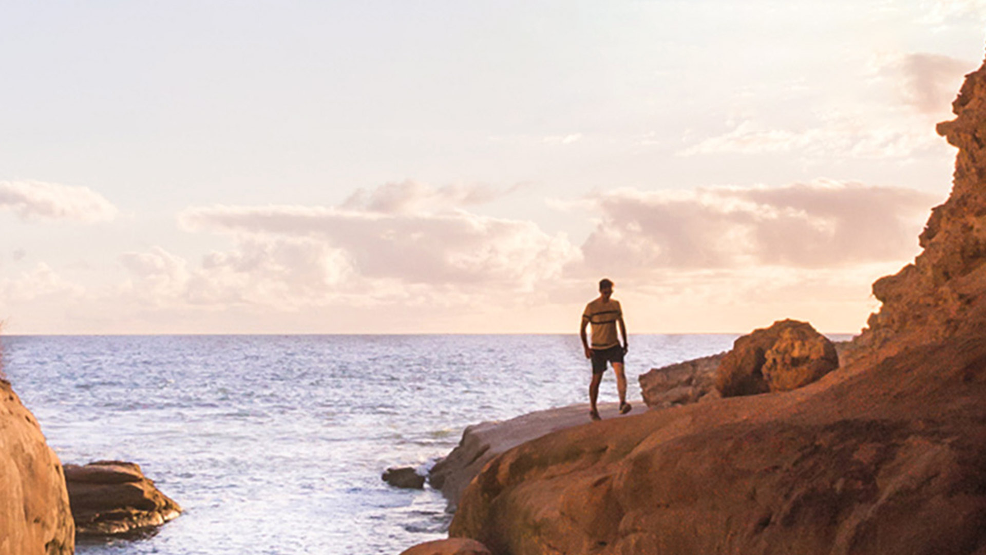 Man walking on rocks near the ocean