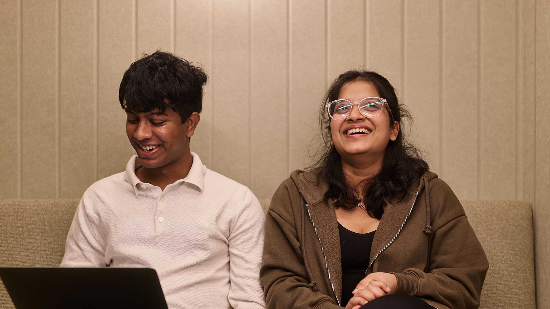 Students sitting with their laptop smiling