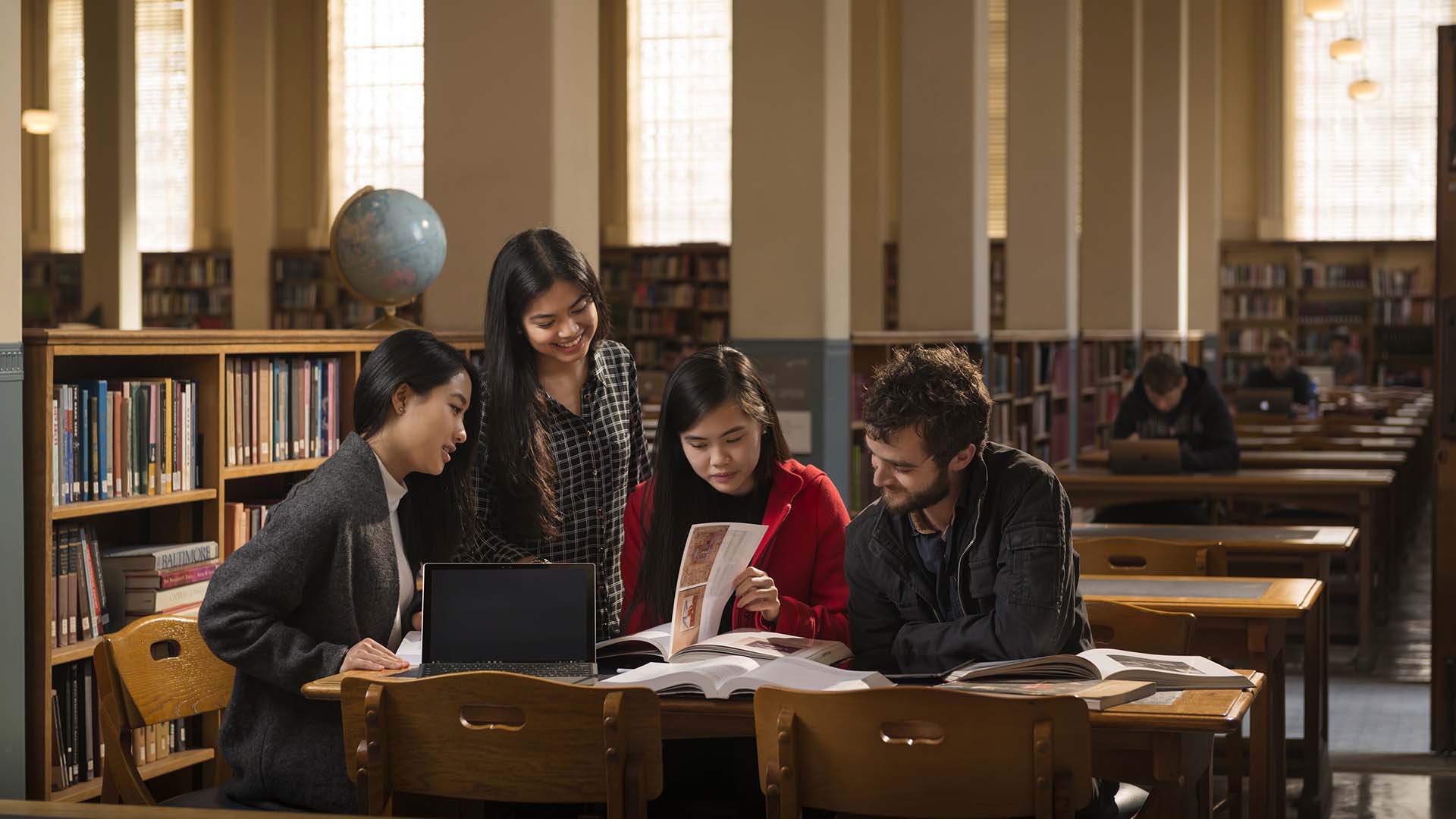 students sitting inside the library looking through books