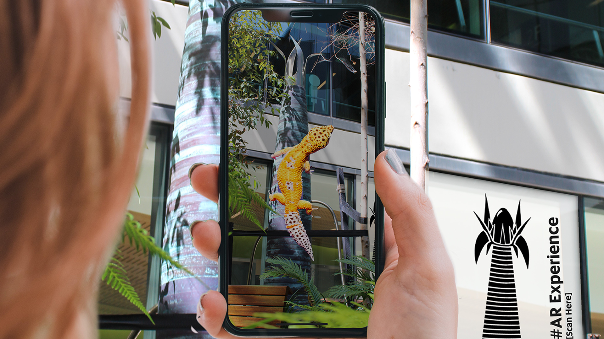 Person holding up a phone that shows a lizard on a tree using artificial reality