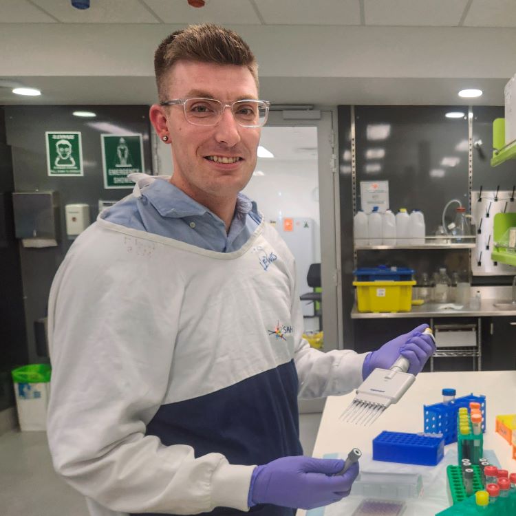 Photo of Dr Stewart Ramsay in the lab holding a pipette.