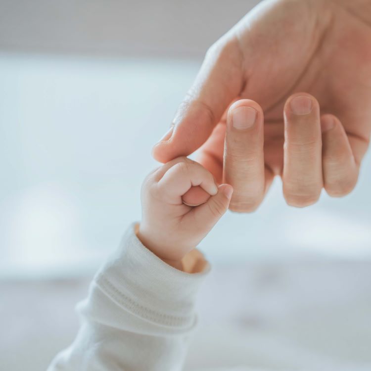 Stock image of a mother holding a baby's hand