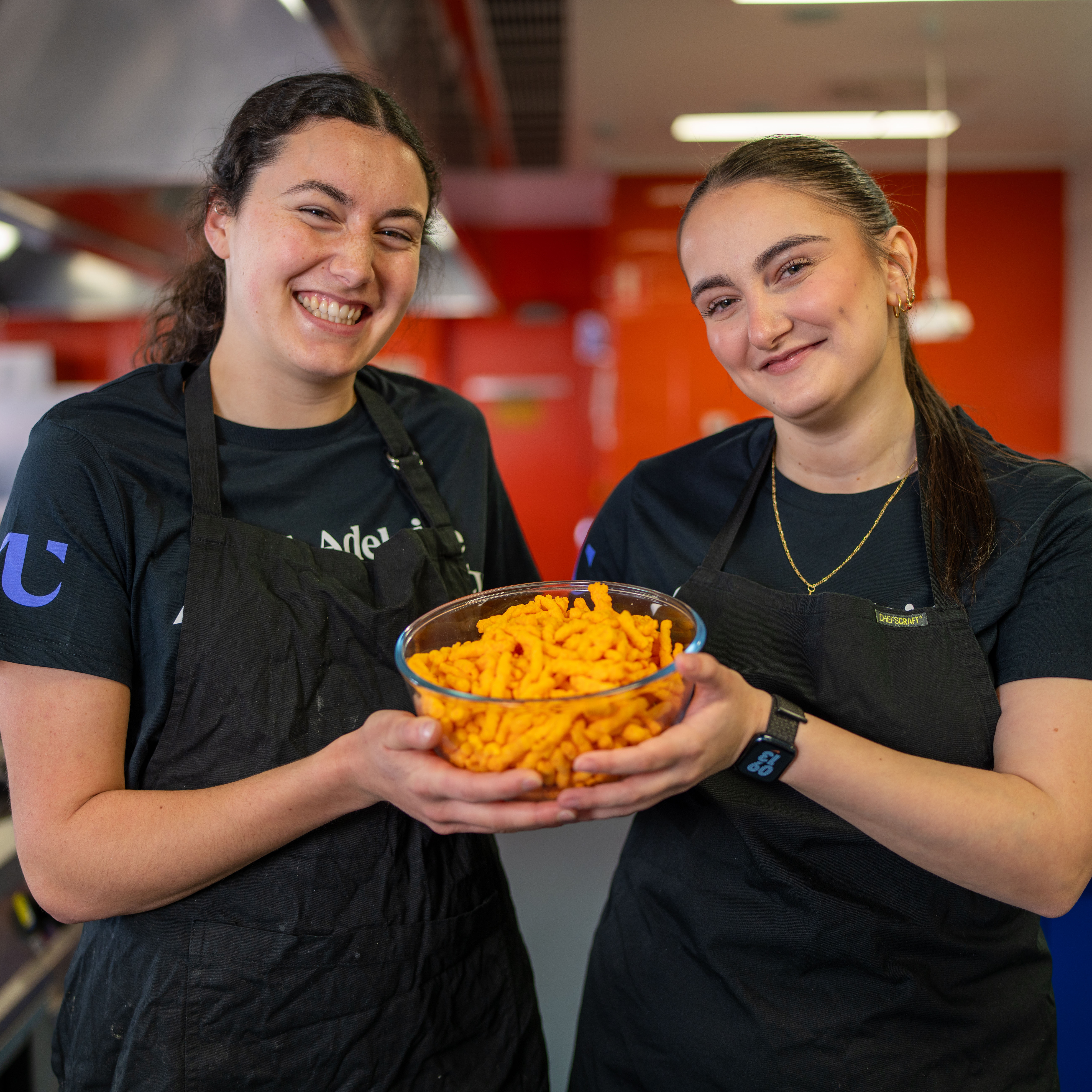Students holding a bowl of Twisties