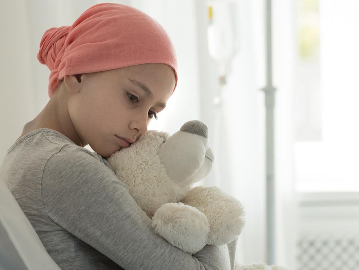 Child with cancer holding a teddy bear