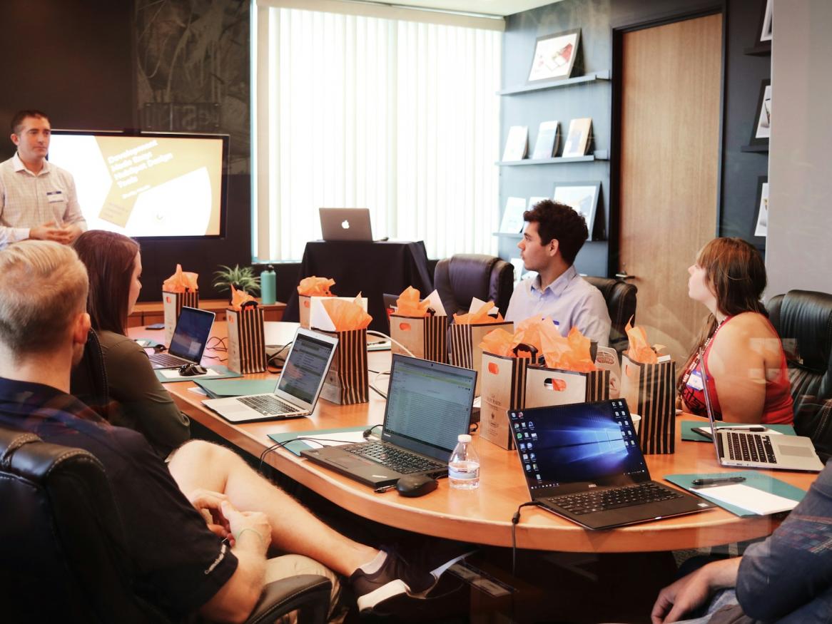 A group of people sit around a boardroom table.