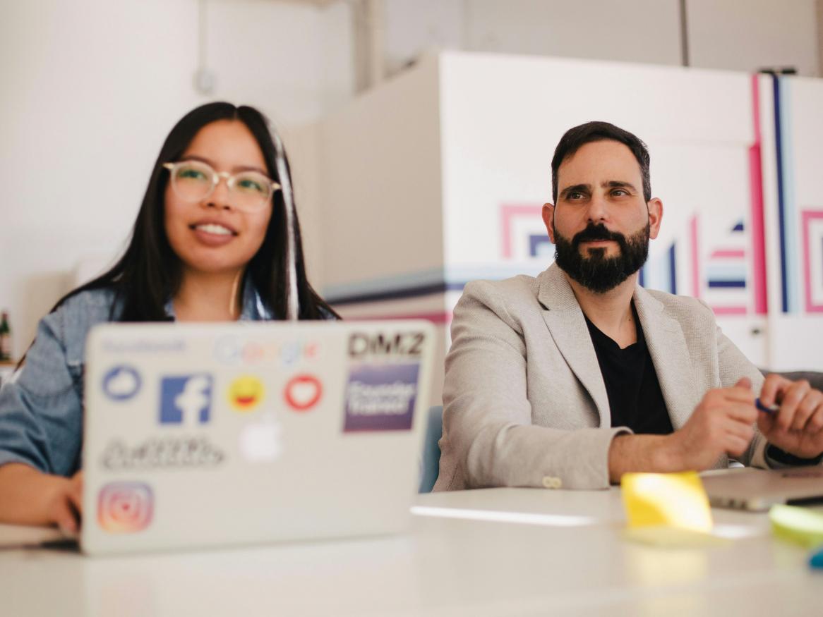 Two people sitting at a desk.