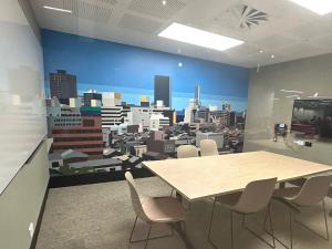 Hub level 3 project room with table, chairs and city scape artwork