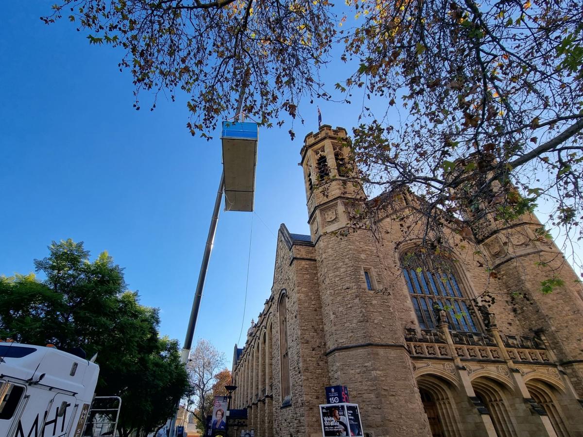 Prefabricated amenities block being lifted by crane over Bonython Hall western side