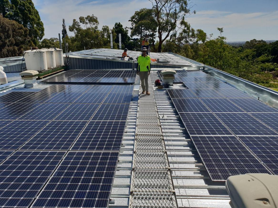 Charles Hawker building solar panels with workers