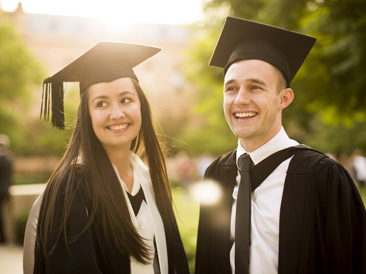 Photo of two very happy graduates in graduation gowns