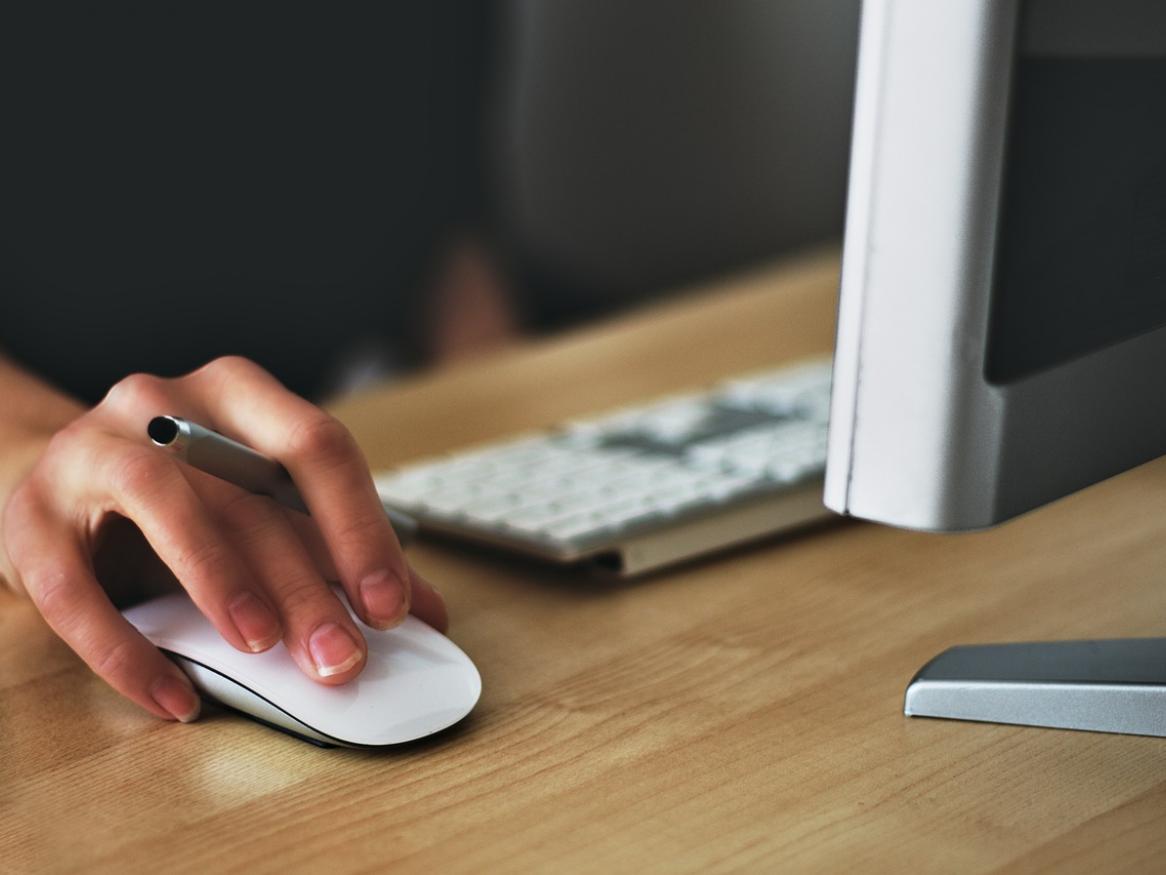 Someone using a computer, holding the mouse