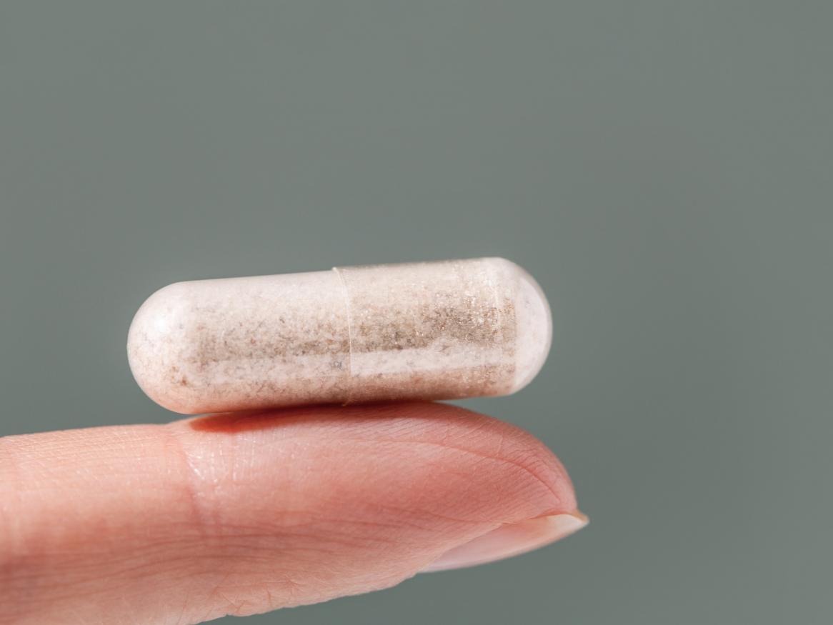 A pill held on a finger