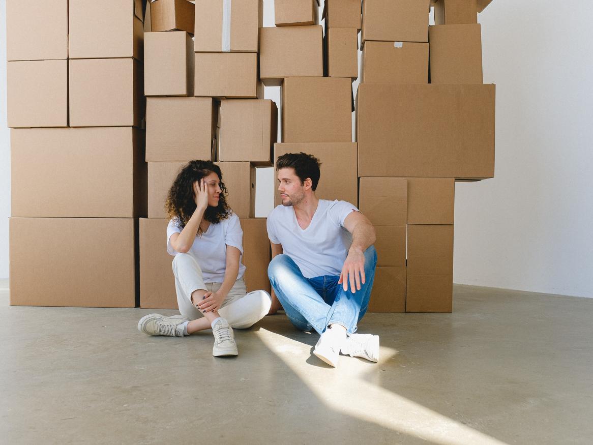 Renters sitting in front of a pile of boxes