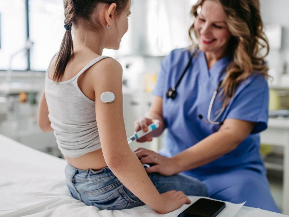 nurse giving injection to girl