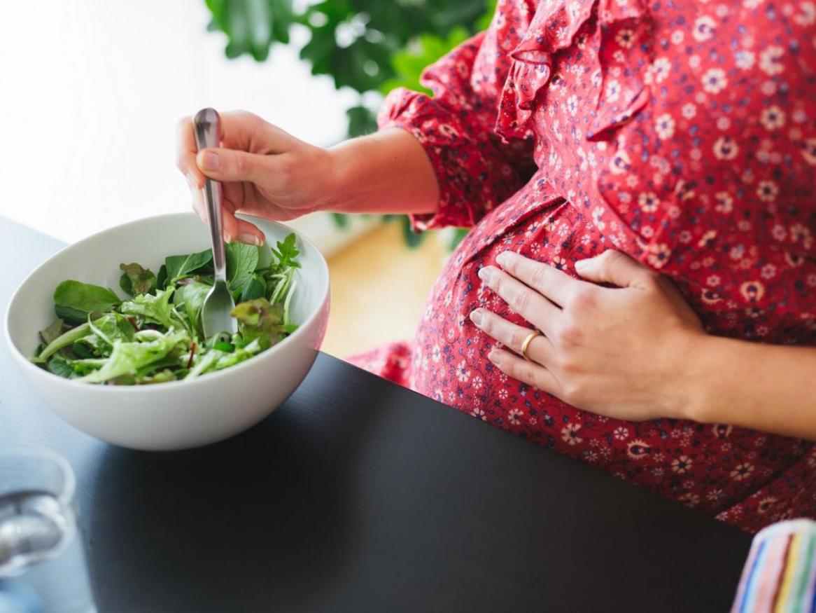 Pregnant woman eating a salad