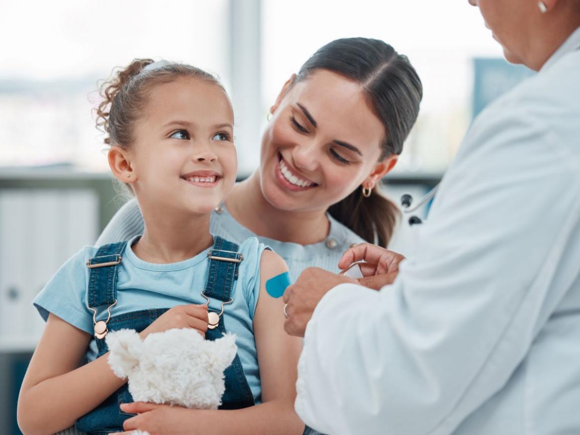 child on mother's lap seeing doctor 