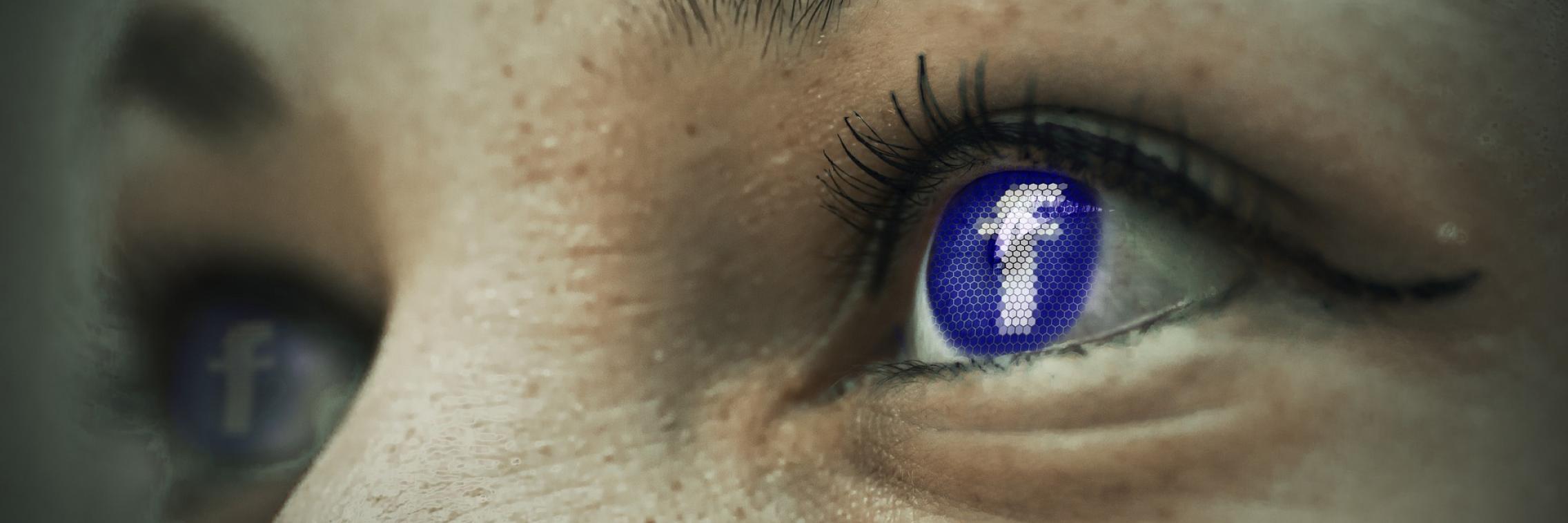 A close up with the facebook logo in the eye