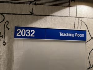 Photo of room 2032 plaque, room directly opposite All Gender bathroom