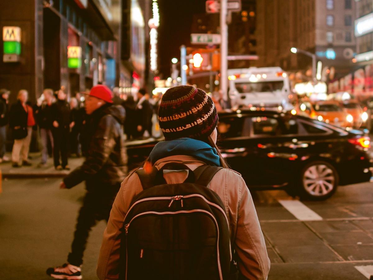 Person walking through bustling city streets.