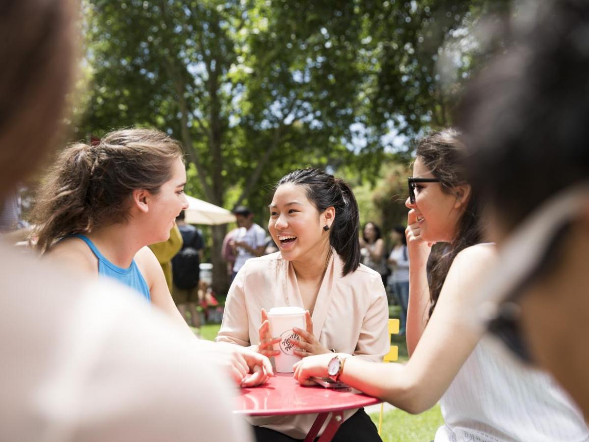 girls laughing at a table - image