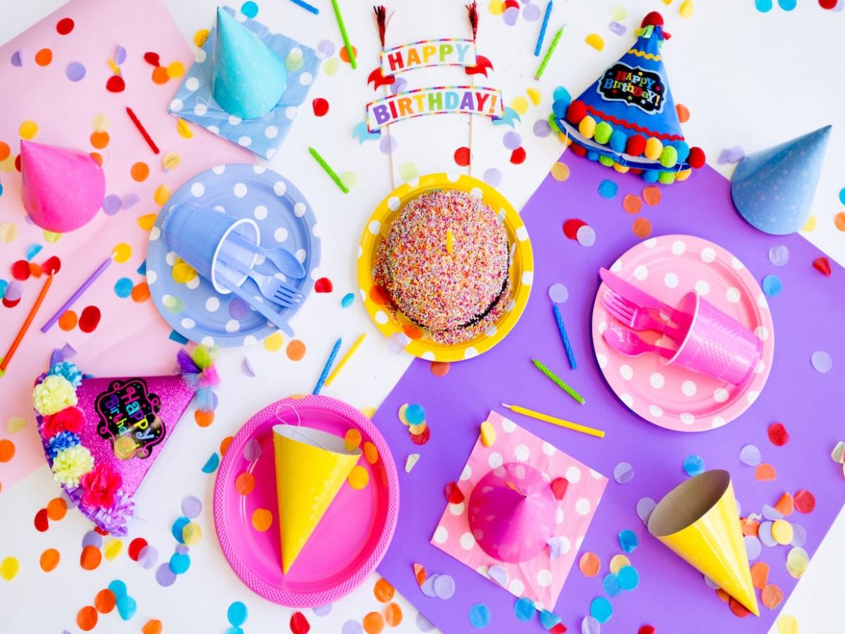 Table full of birthday decorations and cake.