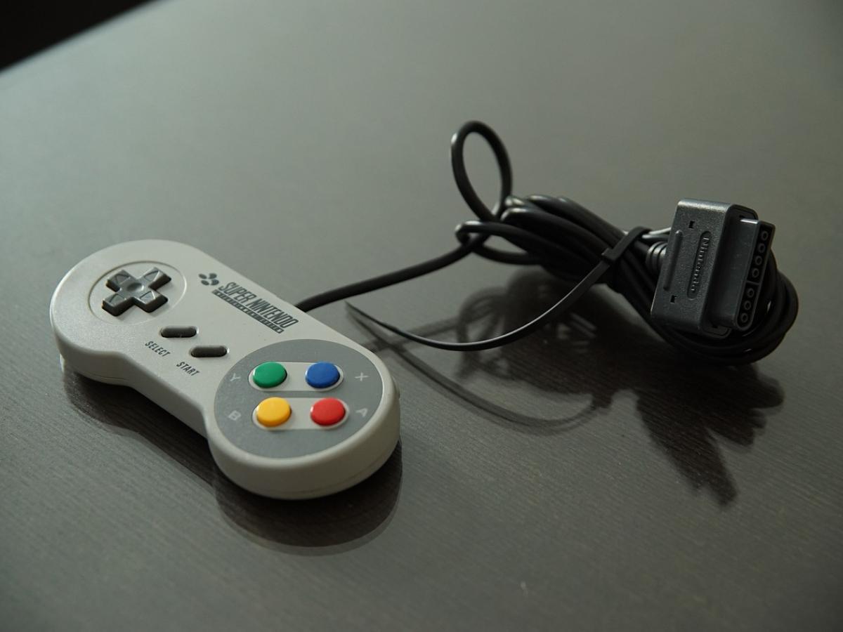 A super Nintendo game controller on a dark tabletop.
