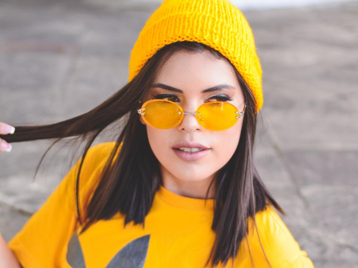 Woman wearing yellow beanie, glasses and t-shirt