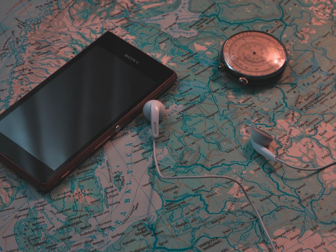 Black phone with hard copy map, compass and ear plugs